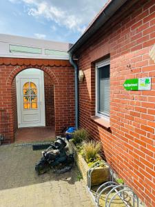 a red brick house with a white door and a sign at City - Appartement in Lengerich +15 photos