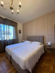 Un dormitorio con una gran cama blanca y una lámpara de araña. en Residenza Sandrini, en Gambassi Terme