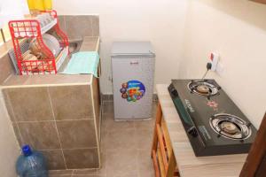 a small kitchen with a refrigerator and a stove at Lulu Stays 1 Bedroom in Nyahururu