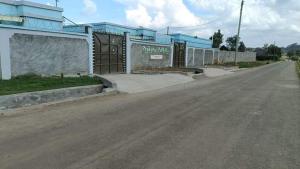 an empty street in front of a blue building at Lulu Stays 1 Bedroom in Nyahururu