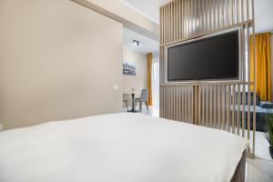 a bedroom with a bed and a flat screen tv at Maniu Flats in Oradea