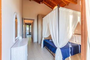 a bedroom with a canopy bed and a tub at Mani Panoramic Seaviews - Luxury Summer Haven in Lévktron