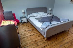 een groot bed in een kamer met een houten vloer bij Chambres d'Hôtes La Vigneronne in Senouillac