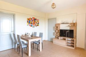 a dining room with a table and chairs and a television at Skafidia Seaview Retreat - Orpheas Seaview Home in Skafidia