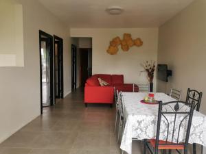 a living room with a red couch and a table at Cosy apartment on the 1st floor in Curepipe