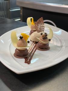 une assiette blanche avec des desserts au chocolat sur une table dans l'établissement Hotel Restaurant Chartron, à Saint-Donat-sur-lʼHerbasse