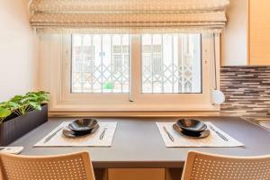 a dining room table with two chairs and a window at Kalamata Lime Studio - Cozy Gem with Private Parking in Kalamata