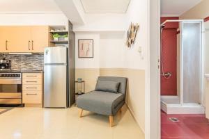 a kitchen with a chair and a refrigerator at Kalamata Lime Studio - Cozy Gem with Private Parking in Kalamata
