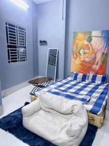 1 dormitorio con 1 cama con una pintura en la pared en Nhà Nghỉ Thành Đạt, en Can Tho