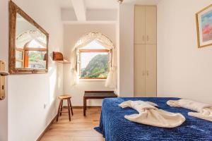 Schlafzimmer mit einem Bett mit blauer Bettwäsche und einem Spiegel in der Unterkunft Stemnitsa Stone Residence - Cosy Mountain Escape in Stemnitsa