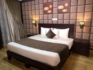 Newland Luxury Hotels and Apartments في أبوجا: غرفة نوم بسرير كبير عليها شراشف ووسائد بيضاء