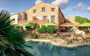 un edificio con piscina frente a un edificio en Auberge Du Roua, en Argelès-sur-Mer