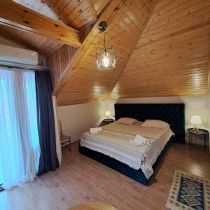 1 dormitorio con cama grande en el techo de madera en Davit batoni Guest house en Mtskheta
