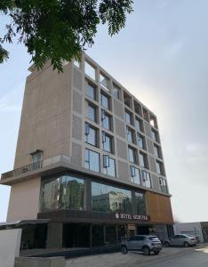a hotel building with cars parked in front of it at Hotel Grand Nidhivan in Nagpur
