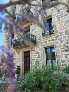 - un bâtiment en pierre avec des fenêtres et une porte dans l'établissement La Maison de famille, à Boën
