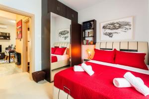 une chambre avec un lit rouge avec des oreillers rouges dans l'établissement Sweet Home Kalamata Central Comfort and Warmth, à Kalamata