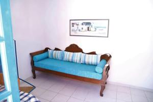 a blue couch in a corner of a room at Santorini Seaside Retreat - Flora's Summer Escape in Perissa