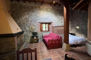 um quarto com uma cama e uma parede de pedra em Los Acebos de Pena Cabarga em Sobremazas