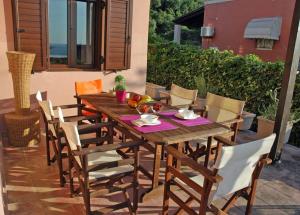 a wooden table and chairs on a patio at Skafidia Villa Yucca - Garden Haven Retreat in Skafidia