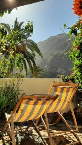 dwa krzesła siedzące na patio z widokiem na góry w obiekcie Casa Avocado w mieście Valle Gran Rey