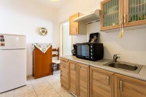 a kitchen with a sink and a microwave at Kalamata City Nest - Central & Cozy Hideout in Kalamata