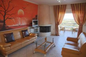 a living room with a couch and a tv at Schinias Bright Spacious Maisonette-Panoramic View in Marathon