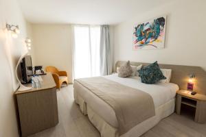 a hotel room with a bed and a television at Cristal Hôtel & Spa in Cannes