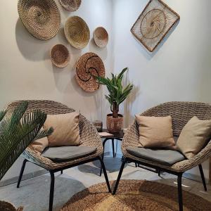 two chairs and a table with a plant on a wall at Cristal H&ocirc;tel & Spa in Cannes