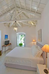 a large white bedroom with a large white bed at A Sea-licious Vacation - Chic & Style in Hydra in Hydra