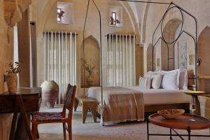 a bedroom with a bed and a table and a chair at Aruramardin in Mardin