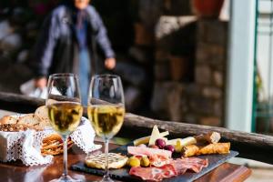 dos copas de vino y una bandeja de comida en Unwind and Relax at the Vilaeti 1871 Retreat, en Agios Konstantinos