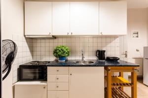a kitchen with white cabinets and a sink at Kitries Summer Getaway - Eden Sandy Suite in Kitriaí