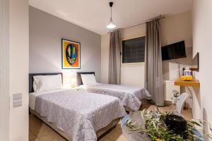 a hotel room with two beds and a tv at Kitries Summer Getaway - Eden Sandy Suite in Kitriaí
