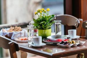 una mesa con comida y un jarrón de flores en Vilaeti Havgas Getaway - Cretan Cozy Home, en Agios Konstantinos
