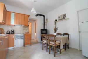 y cocina con mesa, sillas y fogones. en Vilaeti Havgas Getaway - Cretan Cozy Home, en Agios Konstantinos