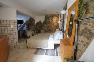 1 dormitorio con 1 cama grande en una habitación de piedra en Vilaeti Stone House - Cretan Cozy Nest, en Agios Konstantinos