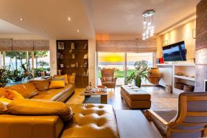 a large living room with a couch and a tv at Sunset Paradise - Verga's Utimate Seaview Getaway in Mírton
