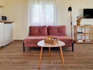 a living room with a red couch and a table at Cozy Owl's Studio Home in Pyrgos
