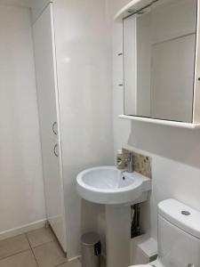 a white bathroom with a sink and a toilet at Park Cottage - Cosy 1 bedroom in Spinney Hill