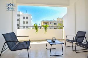 Zimmer mit 3 Stühlen und einem Tisch auf dem Balkon in der Unterkunft SeaWitch Apartment in Larnaka