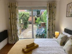 um quarto com uma cama e uma porta de vidro deslizante em Park Cottage - Cosy 1 bedroom em Spinney Hill