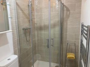 a shower with a glass door in a bathroom at Park Cottage - Cosy 1 bedroom in Spinney Hill