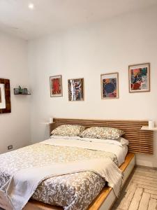 a bedroom with a bed and some pictures on the wall at Roma Caracalla apartament with garden in Rome