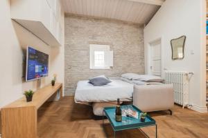 una camera con letto, divano e tavolo di Dimora della Stilista: casa nel borgo di Rimini a Rimini