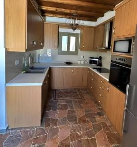 cocina con armarios de madera y suelo de piedra en Ligaria Stone Maisonette Gem in Folegandros Heart, en Áno Meriá