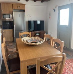 cocina con mesa de madera con sillas y TV en Ligaria Stone Maisonette Gem in Folegandros Heart, en Áno Meriá