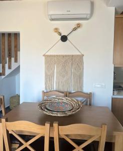 Captain's Villa - Sea Serenity in Folegandros في Áno Meriá: غرفة طعام مع طاولة خشبية ومروحة +18 صورة