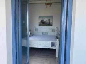 Áno Meriá的住宿－Folegandros Enchanting Cycladic Home Sunset Views，一间小卧室,配有床和玻璃门