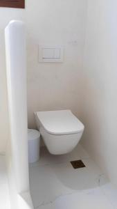 a white bathroom with a toilet in a room at Folegandros Serenity - Livadaki Summer Hideaway in Áno Meriá