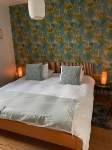 a bedroom with a bed with a blue and green wallpaper at La Majolique in Namur